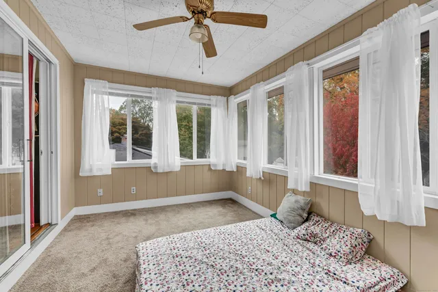 a bedroom with a bed and a large window