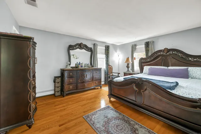 a bedroom with a bed and wooden floor