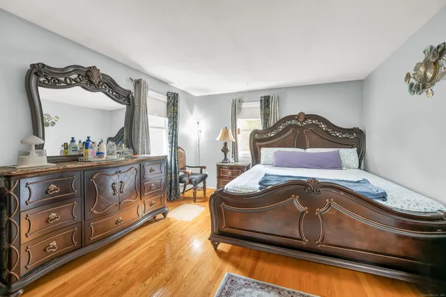 a bedroom with a bed and a mirror on the dresser