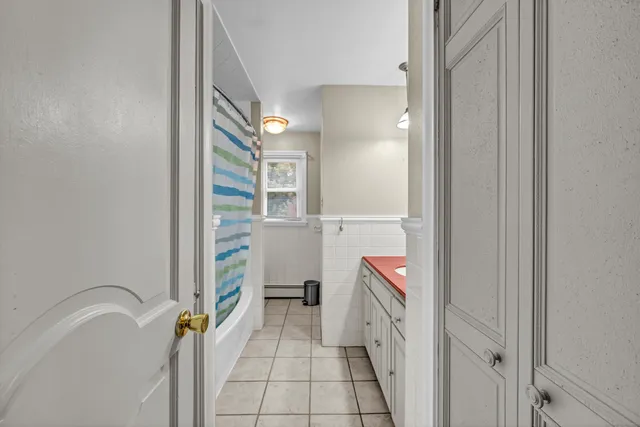 a bathroom with a tub sink mirror and toilet
