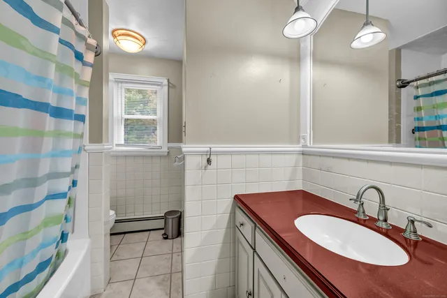 a bathroom with a granite countertop sink a mirror and shower