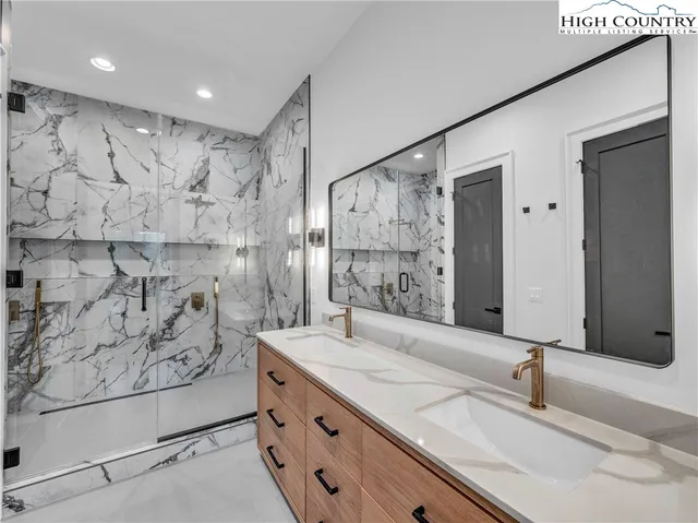 a bathroom with a granite countertop sink a mirror and shower