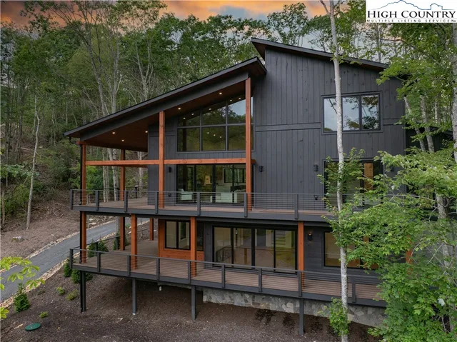 a view of wooden house with a yard and sitting area