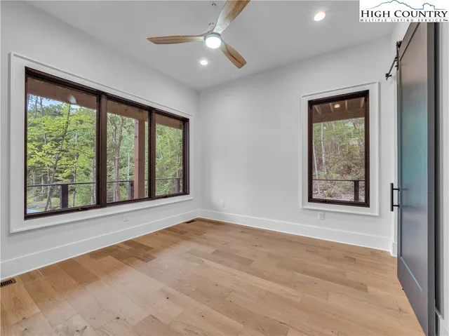 a view of an empty room with a window and kitchen view