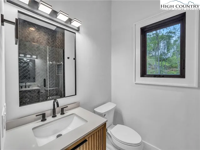 a bathroom with a sink vanity mirror and toilet