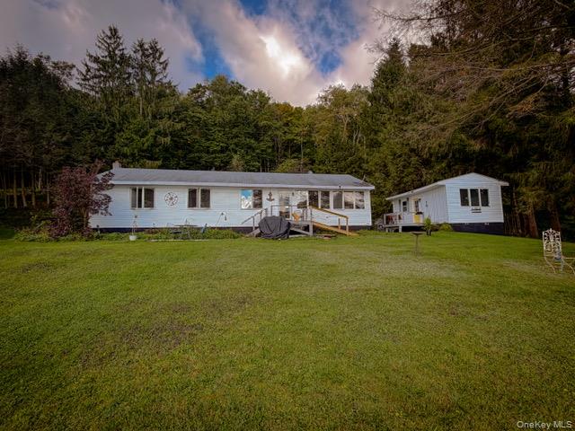 274 Crowley Road Roscoe, NY 12776 - Photo 8 of 29 Expansive green lawn with two white-sided structures, framed by mature trees