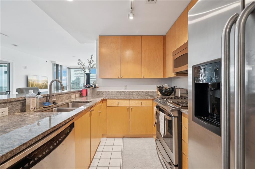 3338 Peachtree Road Northeast, Unit 3006 Atlanta, GA 30326 - Photo 13 of 35 a kitchen with stainless steel appliances granite countertop a sink a stove and a refrigerator