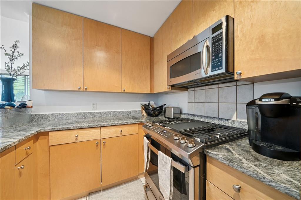 3338 Peachtree Road Northeast, Unit 3006 Atlanta, GA 30326 - Photo 15 of 35 a kitchen with granite countertop a stove top oven microwave and cabinets