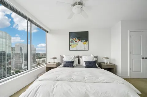 a bedroom with a large bed and a chandelier