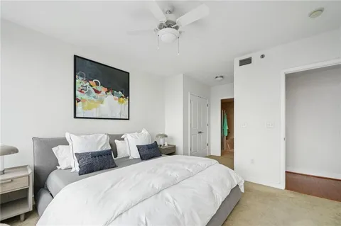 a bedroom with bed and a painting on the wall