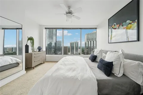 a spacious bedroom with a bed and glass walk in closet