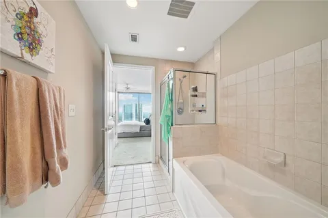 a bathroom with a tub a sink and a large mirror