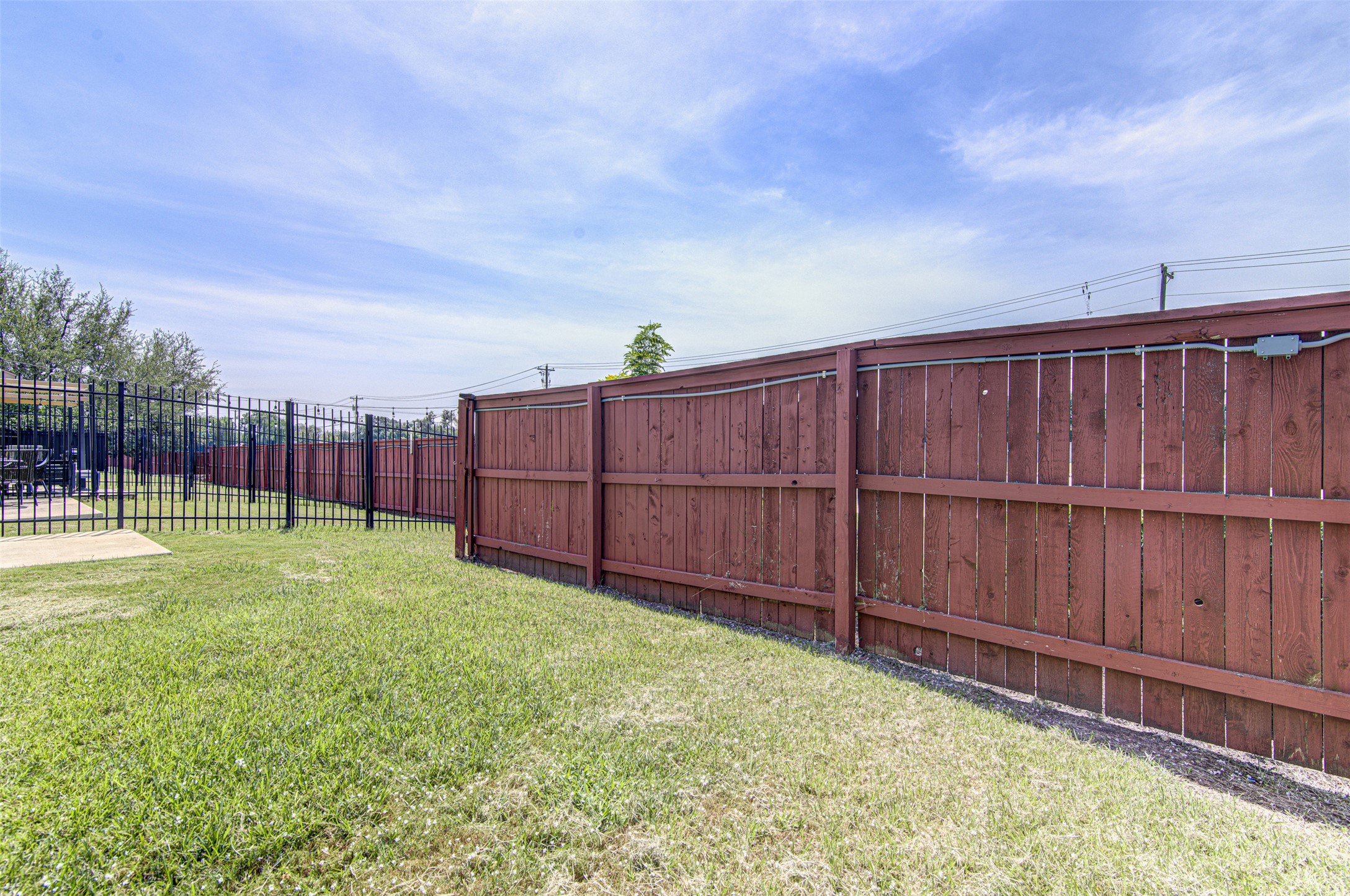 1407 Airedale Road, Unit 1104 Austin, TX 78748 - Photo 25 of 26 A well-maintained wooden fence provides privacy for a backyard space with vibrant green grass.