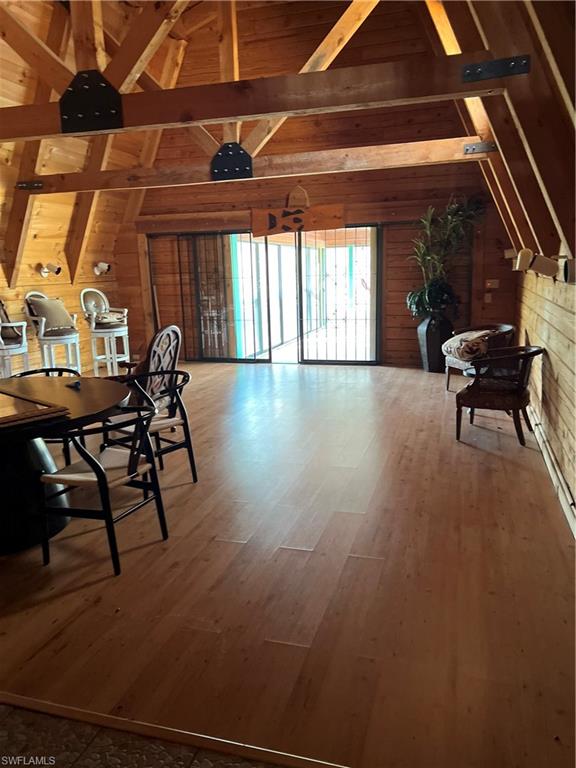 4395 18th Street Northeast Naples, FL 34120 - Photo 6 of 6 Dining area featuring hardwood / wood-style floors, vaulted ceiling with beams, and wooden walls