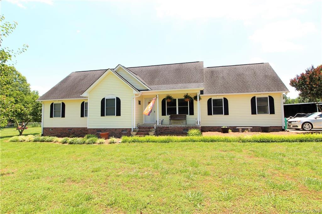 a view of house with yard and swimming pool