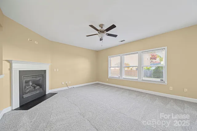 a view of empty room with a fireplace and fan