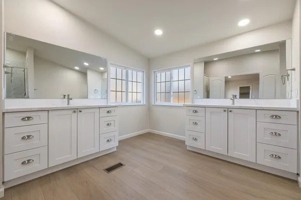 a bathroom with a granite countertop sink a mirror and a shower