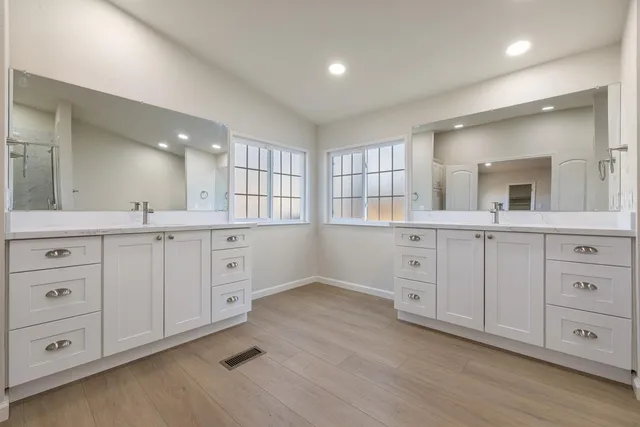a bathroom with a granite countertop sink a mirror and a shower