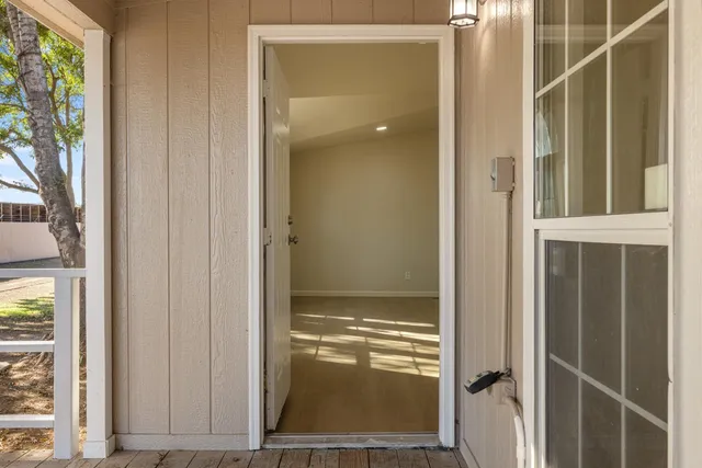 an empty room with wooden floor and a hallway