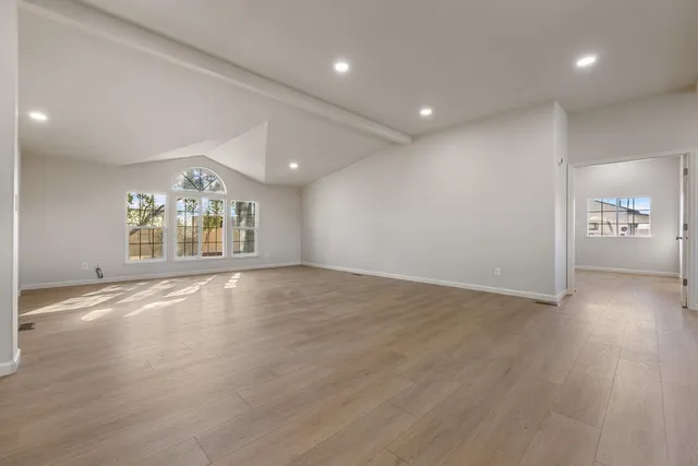 an empty room with wooden floor and a window