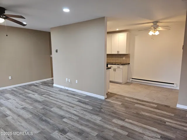 a view of a livingroom with a dishwasher kitchen stove and wooden floor