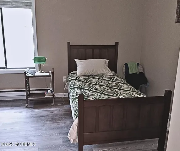 a bedroom with a bed wooden floor and a potted plant