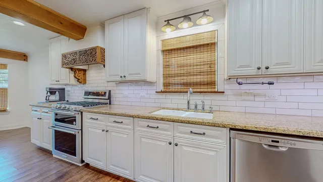 a kitchen with granite countertop white cabinets and white appliances