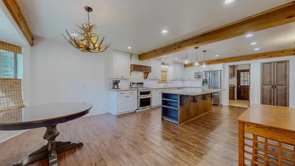 a large kitchen with a counter space a sink stainless steel appliances and cabinets