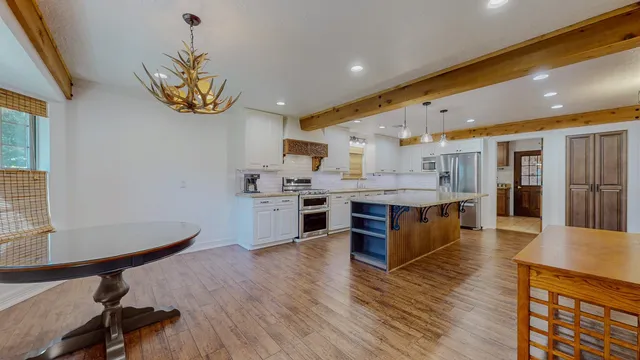 a large kitchen with a counter space a sink stainless steel appliances and cabinets