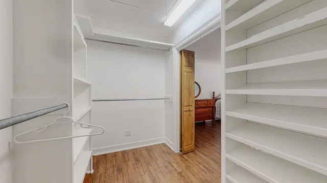 a view of walk in closet with empty racks