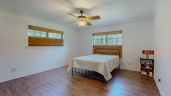 a bedroom with a bed and wooden floor