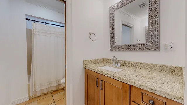 a bathroom with a granite countertop sink and a mirror