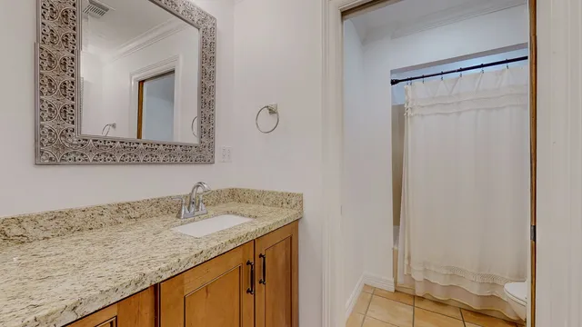 a bathroom with a granite countertop sink and a mirror