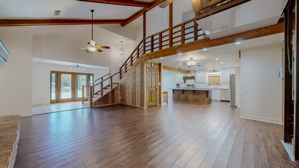 a view of an entryway with wooden floor stairs and a chandelier