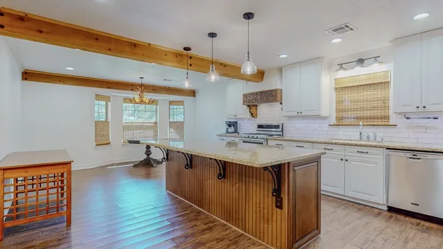 a kitchen with a sink and wooden floor