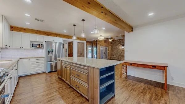 a kitchen with stainless steel appliances kitchen island granite countertop a stove and a sink