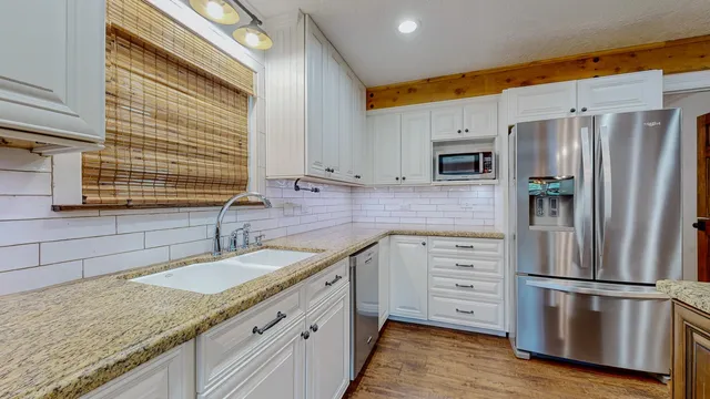 a kitchen with stainless steel appliances granite countertop a refrigerator sink and stove