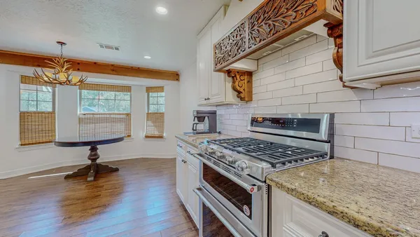 a kitchen with stainless steel appliances granite countertop a stove a sink and a wooden cabinets