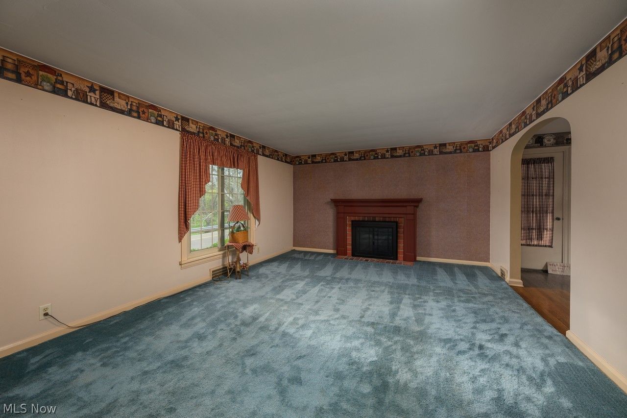 1422 Monument Road Northwest Canton, OH 44703 - Photo 6 of 31 Living room with large picture window, fireplace and carpet flooring