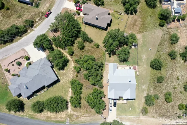 an aerial view of a house with a yard and tennis court