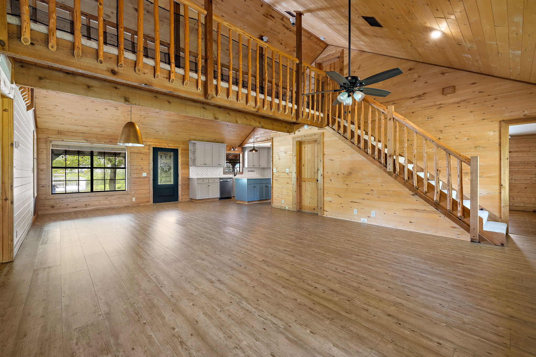 571 Balch Road Elgin, TX 78621 - Photo 8 of 33 Vaulted wood-paneled ceiling with a dark-toned ceiling fan, a wooden staircase, and wood-finish flooring