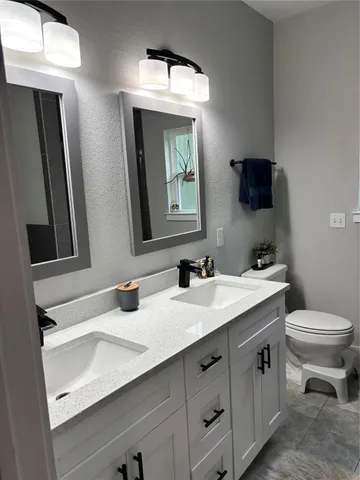 a bathroom with a toilet sink and mirror