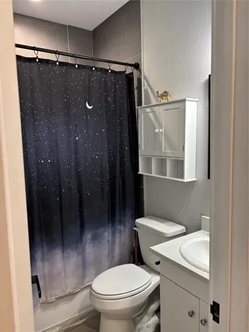a bathroom with a granite countertop toilet sink and shower