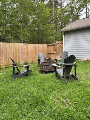 a backyard of a house with barbeque oven and wooden fence