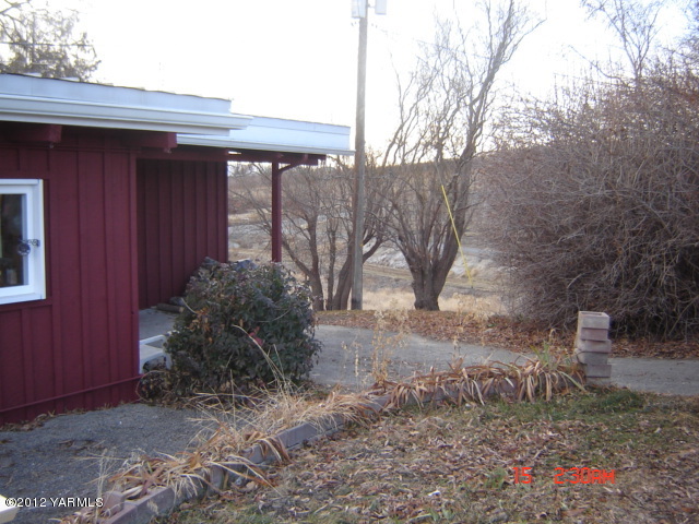 801 Clark Road Wapato, WA 98951 - Photo 6 of 28 a backyard of a house with large trees and table