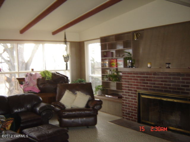 801 Clark Road Wapato, WA 98951 - Photo 9 of 28 a living room with furniture a flat screen tv and a fireplace