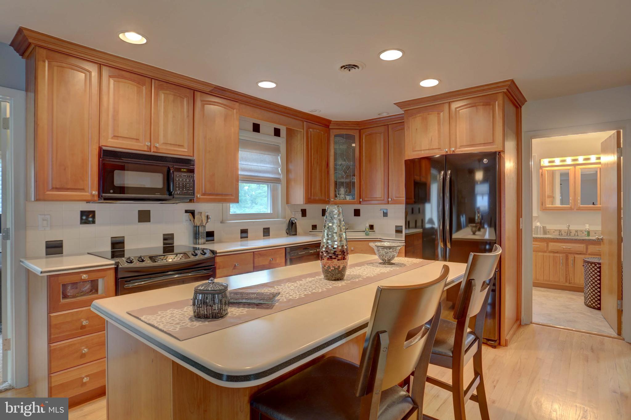 977 Hampden Road Elizabethtown, PA 17022 - Photo 4 of 25 a kitchen with stainless steel appliances granite countertop a sink a stove a refrigerator cabinets and a dining table with wooden floor