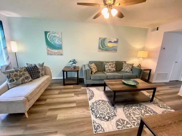 a living room with furniture and wooden floor