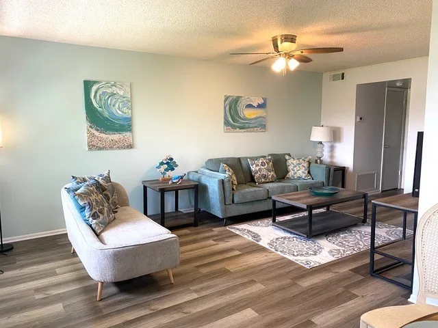 a living room with furniture and a wooden floor