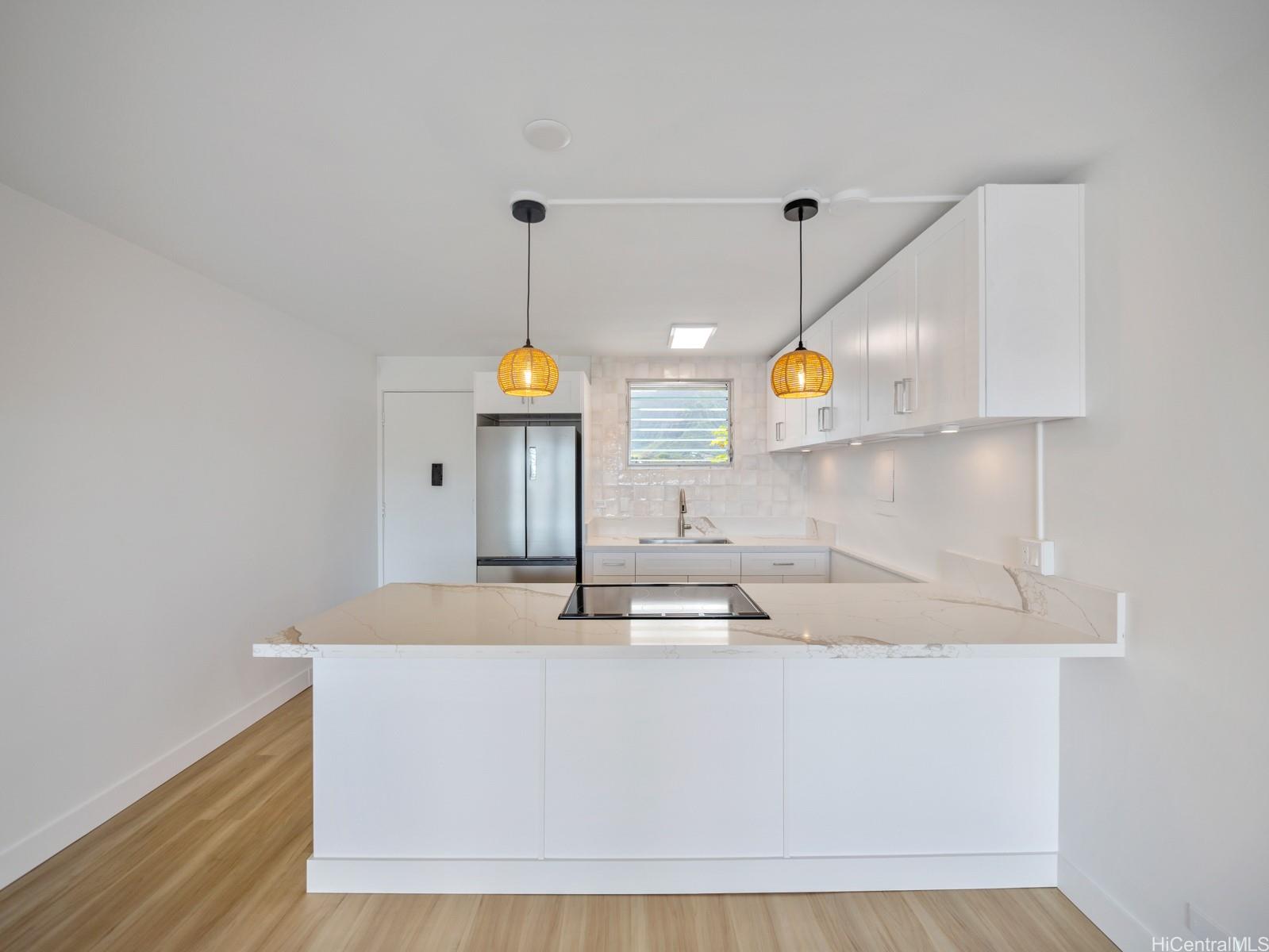45-342 Lilipuna Road, Unit 204 Kaneohe, HI 96744 - Photo 18 of 25 a kitchen with kitchen island white cabinets and stainless steel appliances